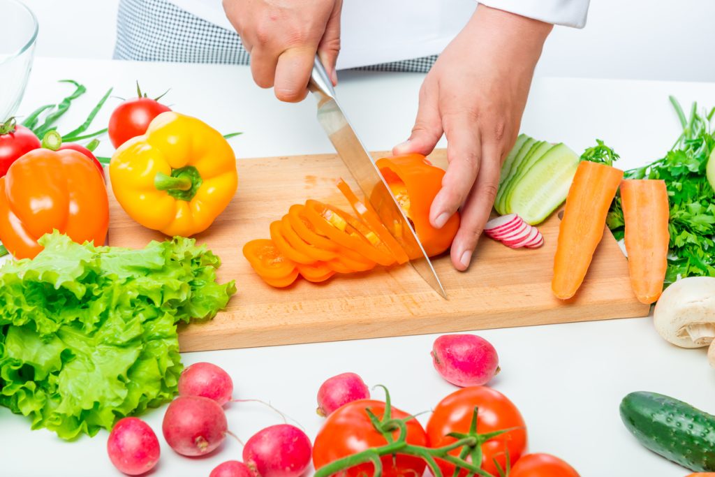 Mãos cortando vegetais